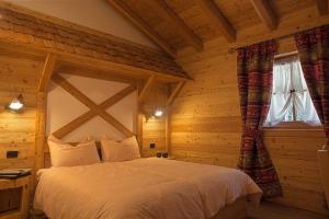 a bedroom with a bed in a wooden room at Chalet Camping Faè 2 in Madonna di Campiglio