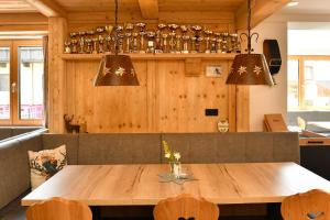 une salle à manger avec une table en bois et quelques lumières dans l'établissement Pension Eichenheim, à Westendorf