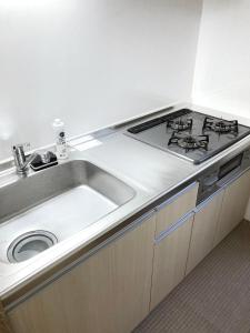 a kitchen with a sink and a stove at guesthouse築港 in Osaka