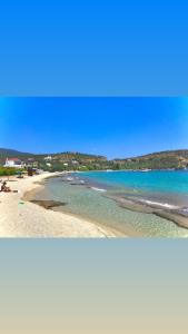 two pictures of a beach with the ocean and the sky at Golden Coast Panagias Apartment in Volos