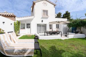 a backyard with a white house with a lawn at Casa Alejandro in Marbella