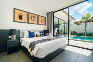 a bedroom with a large bed and a swimming pool at Villa Bunga Lily - Sumptuous 3BR Luxury Private Villa in Canggu in Canggu