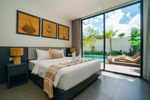 a bedroom with a large bed and a large window at Villa Bunga Lily - Sumptuous 3BR Luxury Private Villa in Canggu in Canggu