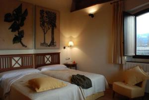 OLATZEA LANDA HOTELA في Arbizu: غرفة فندقية بسريرين ونافذة