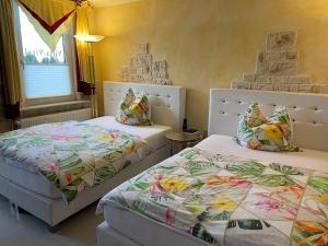 a bedroom with two beds and a window at Hotel Villa Vital Munster in Munster im Heidekreis