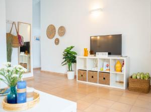 a living room with a tv on a white shelf at Casa Menorquina centro Ciutadella in Ciutadella