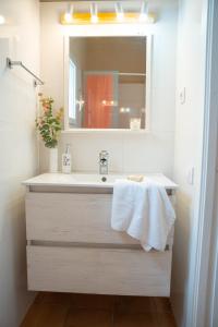 un bagno con lavandino e specchio di Casa Menorquina centro Ciutadella a Ciutadella Altre 22 foto