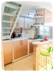 a kitchen with brown cabinets and a green stool at Cosy Duplex" Sidi Bou Said " in Sidi Bou Saïd