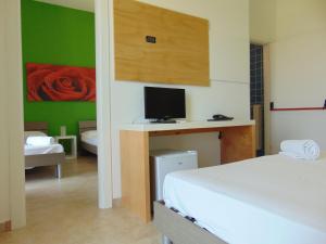 a bedroom with a bed and a desk with a television at Oasis Park Hotel in Torre dell'Orso