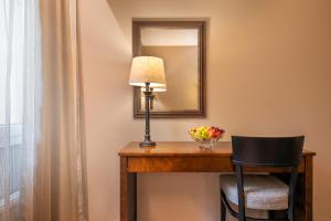 Cette chambre comprend un bureau avec une lampe et un miroir. dans l'établissement Spa Hotel Runni Iisalmi, à Iisalmi