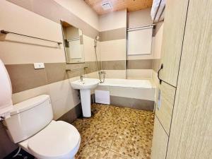 een badkamer met een toilet, een wastafel en een bad bij Sun Shine B&B in Hengchun