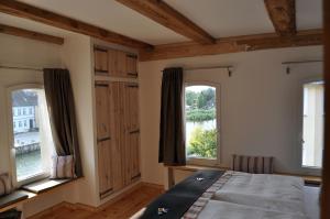 a bedroom with two windows and a bed in it at Der Speicher in Wolgast