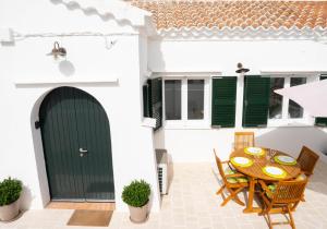 d'une terrasse avec une table, des chaises et une porte verte. dans l'établissement Casa Menorquina centro Ciutadella, à Ciutadella