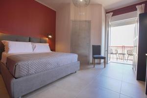 um quarto com uma cama grande e uma varanda em Malù - Bed & Breakfast em Agrigento