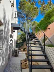 eine Treppe, die zu einem Gebäude mit Treppengeländer führt in der Unterkunft Studio du Roc des Garrigues in Langlade