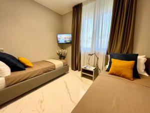 Una habitación de hotel con dos camas y un televisor de pantalla plana. en Darsena Luxury apartments, en Viareggio