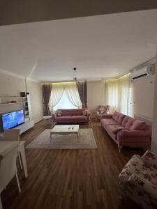 - un salon avec deux canapés roses et une télévision dans l'établissement YZC apart, à Soğuksu