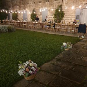 a room with tables and chairs and flowers on the grass at Masseria Spartivento in Conca Specchiulla