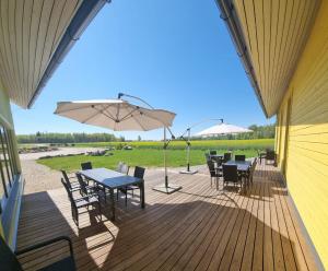 een terras met tafels en stoelen en een parasol bij Auksi motell in Auksi