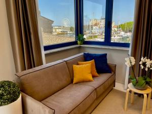 1 sofá en la sala de estar con 2 ventanas grandes en Darsena Luxury apartments, en Viareggio