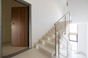 a hallway with stairs and a wooden door at Casa Vacanza Egan Scanzano J in Scanzano