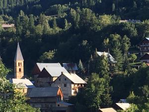 una pequeña ciudad con una iglesia en medio de árboles en Appartement chalet 4 pers 45m2 Puy Saint Vincent en Puy-Saint-Vincent