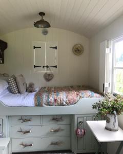 a bedroom with a bed and a desk and a window at Cattlestone Farm in Coolham