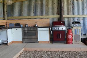 an outdoor kitchen with a stove and a fire extinguisher at Cattlestone Farm in Coolham