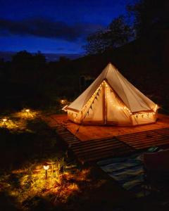 a white tent is lit up at night at Glyndwr Bell Tent in Builth Wells