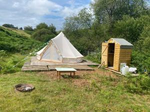 a tent and a table in a field at Glyndwr Bell Tent in Builth Wells