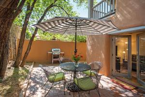a table with chairs and an umbrella on a patio at Casa Anita in Santa Fe