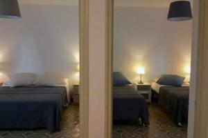 Cette chambre comprend 2 lits et un miroir. dans l'établissement Beach House Focallo (private car park), à Ispica