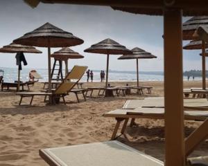 - une plage avec des tables, des chaises et des parasols dans l'établissement Beach House Focallo (private car park), à Ispica