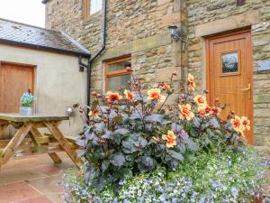 a large pot of flowers in front of a building at The Barn Cottage in Slaley