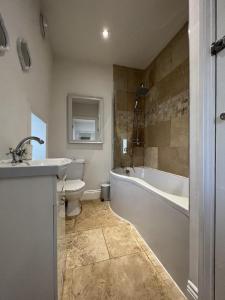 een badkamer met een bad, een toilet en een wastafel bij 3 Bedrooms 2 Bath Cottage Balcony Garden Dogs Free in Berwick-Upon-Tweed