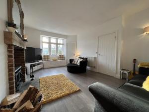 een woonkamer met een bank en een open haard bij 3 Bedrooms 2 Bath Cottage Balcony Garden Dogs Free in Berwick-Upon-Tweed