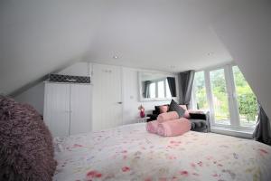een slaapkamer met een groot bed met een roze kussen erop bij 3 Bedrooms 2 Bath Cottage Balcony Garden Dogs Free in Berwick-Upon-Tweed