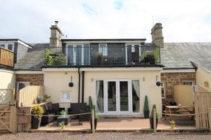 een vrijstaand huis met een terras en een balkon bij 3 Bedrooms 2 Bath Cottage Balcony Garden Dogs Free in Berwick-Upon-Tweed