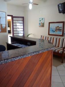 a kitchen with a counter top and a living room at Petit Praia Hotel in Florianópolis