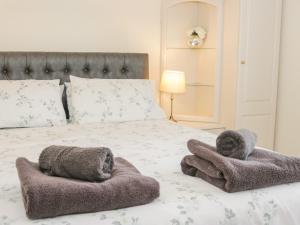 a bedroom with a bed with towels on it at Beausite in Colwyn Bay