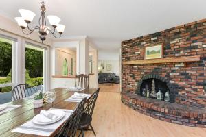 a dining room with a brick fireplace and a dining table at Casa De Kai in Mill Bay