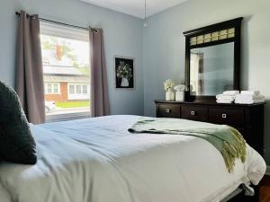 - une chambre avec un lit avec un miroir et une fenêtre dans l'établissement Green Roof Inn - Centrally Located 2BR/1BA Home, à Evansville