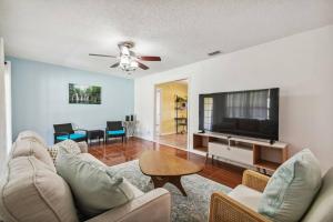 a living room with a couch and a flat screen tv at TRANQUILITY! PRIVATE Gated Estate! Boats, RVs OK! Has Separate Apt, Fishing, Hiking, LOW Rates! in Kissimmee