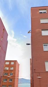 a red brick building next to two tall buildings at Apartamento Santander in Santander