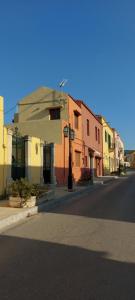 een straat met kleurrijke gebouwen aan de kant van een weg bij Anna's room in Archanes