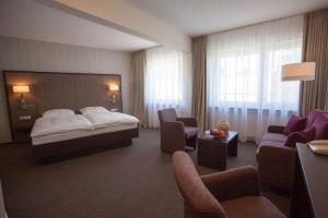 une chambre d'hôtel avec un lit et un canapé dans l'établissement Hotel Kaiserhof, à Siegburg