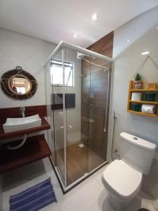 y baño con ducha, aseo y lavamanos. en Residencial Villa Jeri 2 SUÍTES a 300m do MAR, VARANDA, Smart TV, Wi-Fi, ar-condicionado, en Jericoacoara