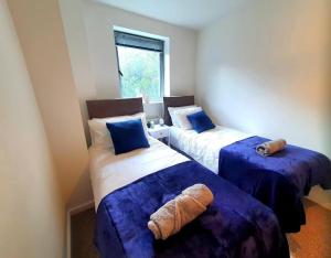 a room with two beds with blue sheets and a window at Long-term Retreat! Family & Business - 5 Beds City Apt & Parking - 中国搬迁 in Leeds