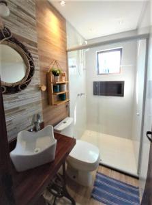 y baño con aseo, lavabo y ducha. en Residencial Villa Jeri 2 SUÍTES a 300m do MAR, VARANDA, Smart TV, Wi-Fi, ar-condicionado en Jericoacoara