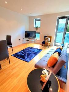 uma sala de estar com um sofá e uma mesa em Long-term Retreat! Family & Business - 5 Beds City Apt & Parking - 中国搬迁 em Leeds